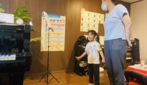 幼い子どもと母親がお歌のレッスンで楽しそうに歌っている様子。