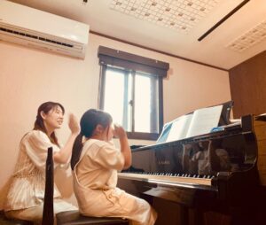 講師と生徒が楽しそうにリズム叩きをしてレッスンをしている様子。